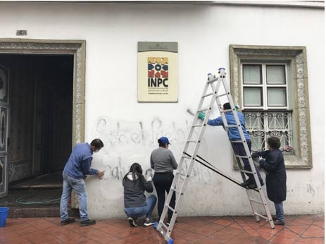 Cleaning graffiti which states “Solo el Pueblo Salva el Pueblo” (only the people can save the people) from the façade of the National Institute of Cultural Heritage (INPC) in Cuenca on October 10, 2019. (Cecilia Bogaard)